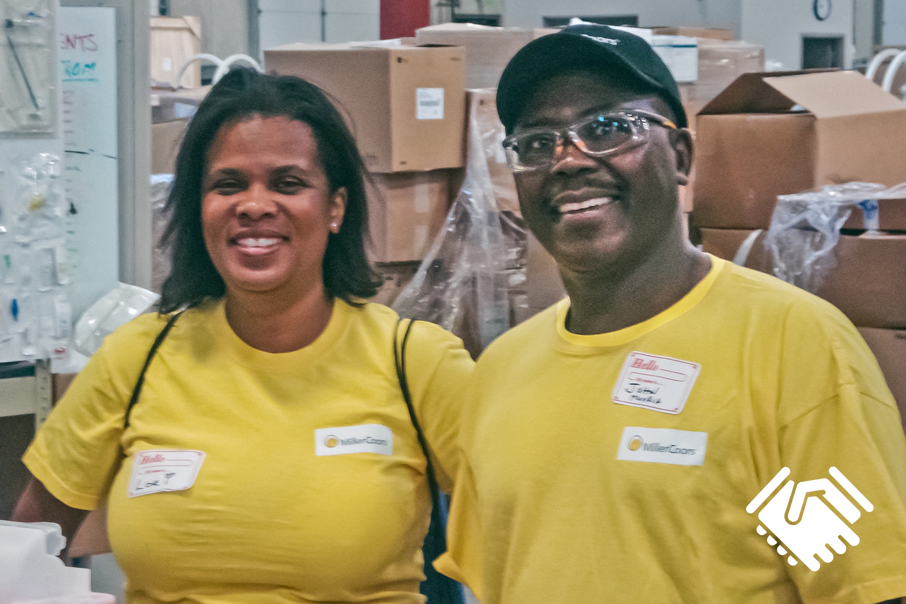 Coors Brewing employees Lori Powell and John Muoria volunteering in the Project C.U.R.E. warehouse in Denver